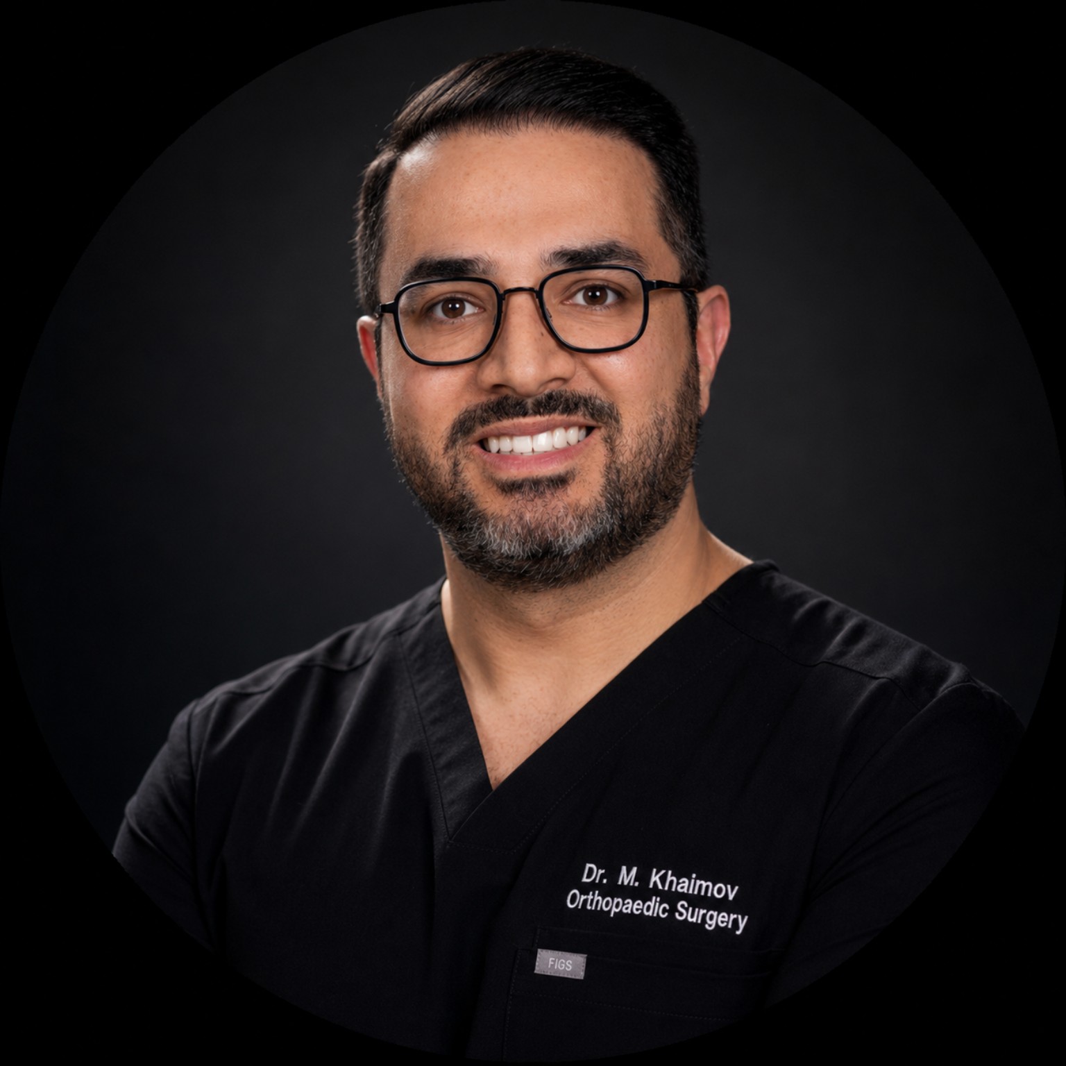 Dr. Mikhail Khaimov wearing black embroidered surgical scrubs